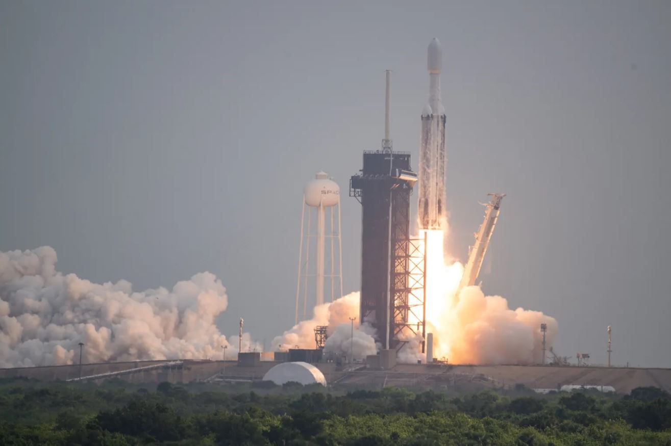 Falcon heavy rocket carrying Psyche spacecraft emits fire and smoke as it lifts off
