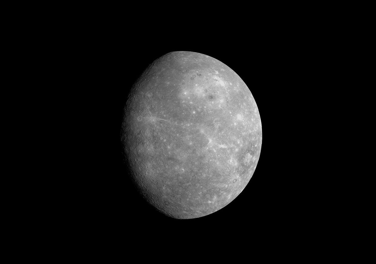 Most of Mercury is visible in this flyby image. It appears gray-colored with white ejecta in craters.
