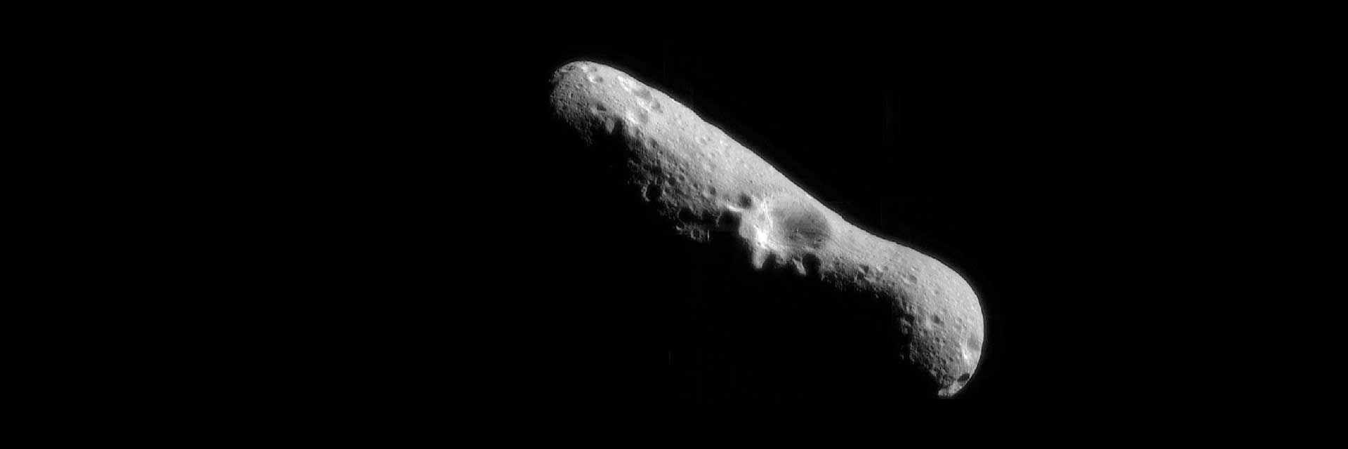 An oblong-shaped asteroid in space with a giant crater near its center
