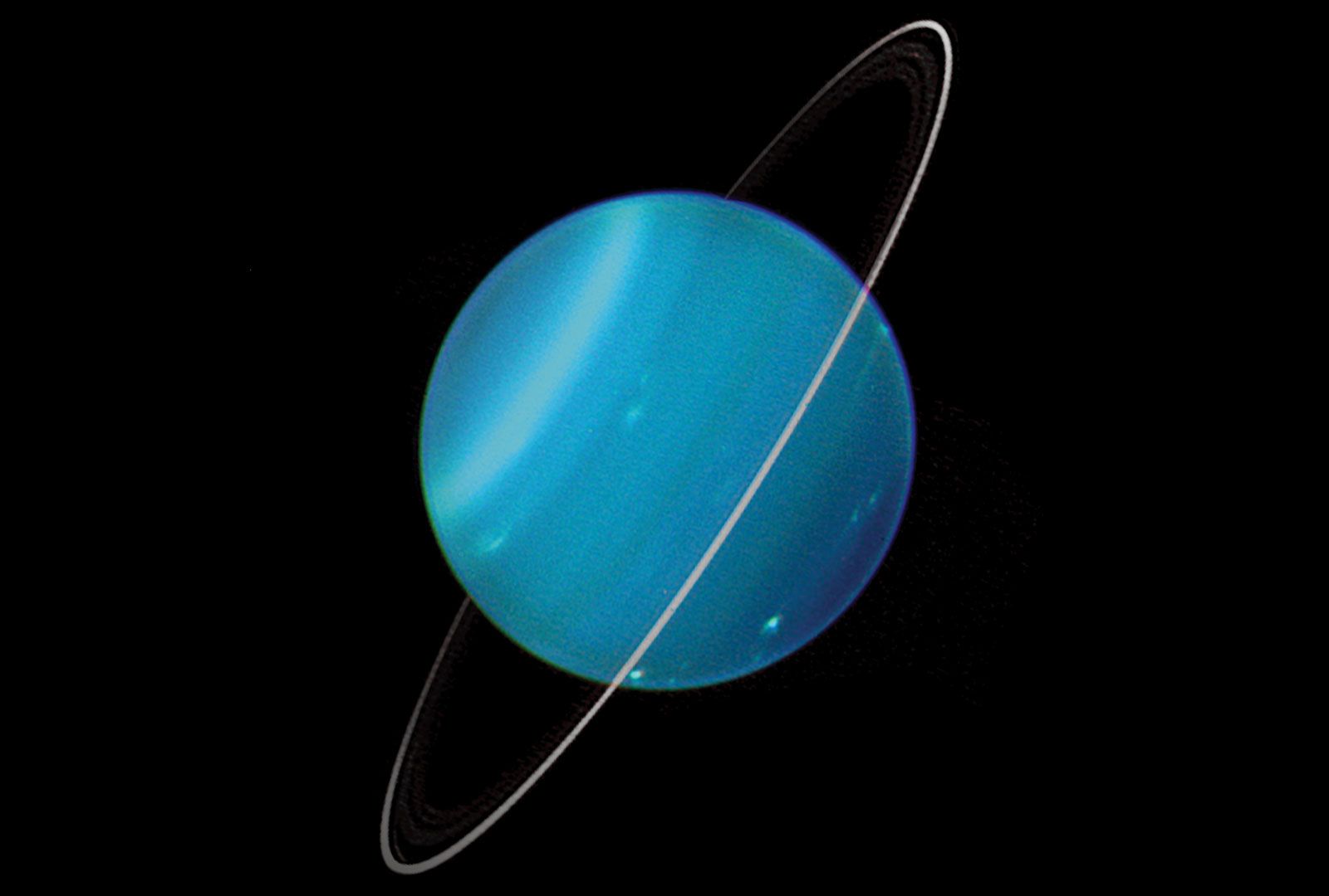 This enhanced image reveals cloud structures in the blue atmosphere of Uranus. Faint rings are visible as well.