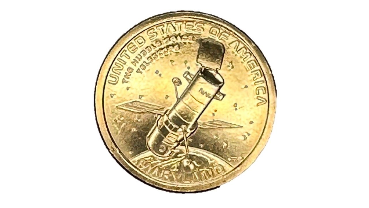 A gold coin is stamped with an image of Hubble floaing over Earth.