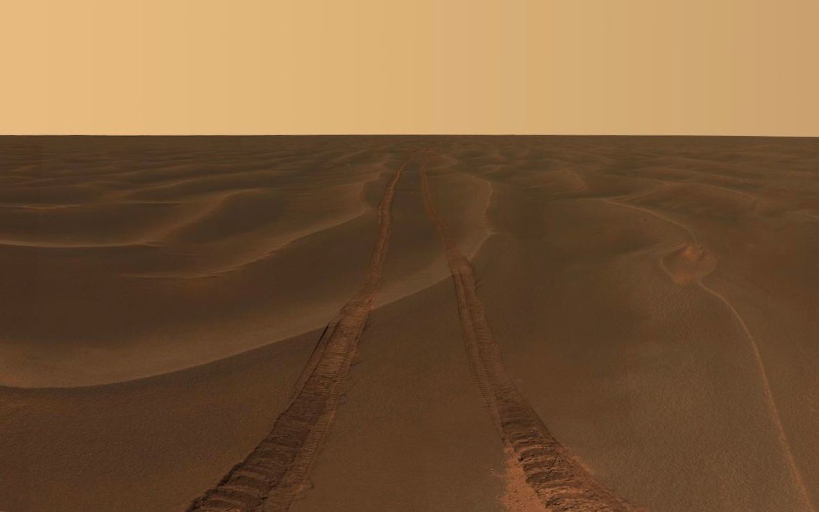 vast plain of dunes with rover tracks leading to horizon