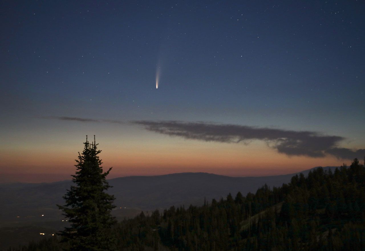 Beautiful comet over mountains an a pre-dawn skies.