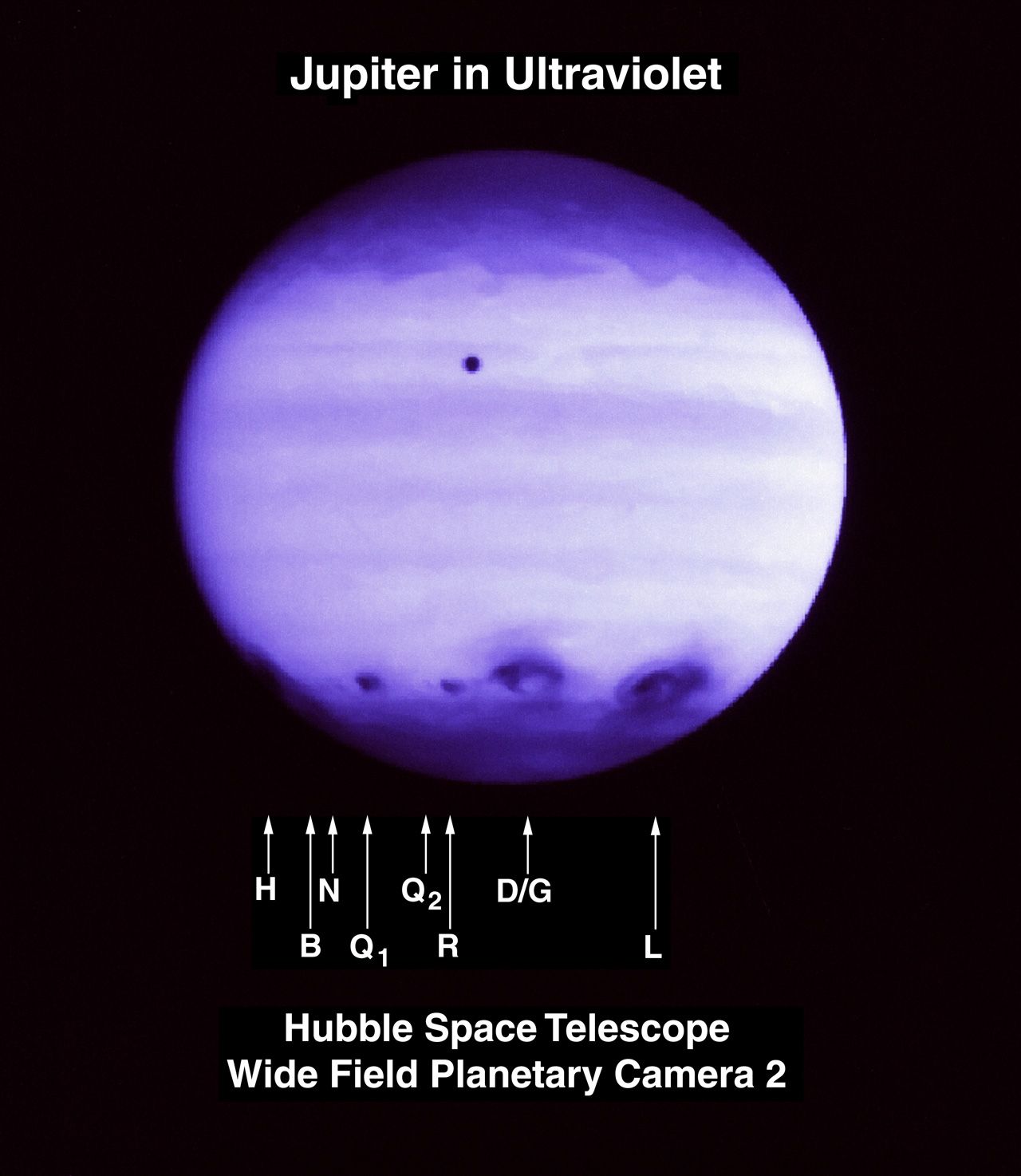Purplish view of Jupiter with a band of dark impact images around the bottom quarter of the planet.