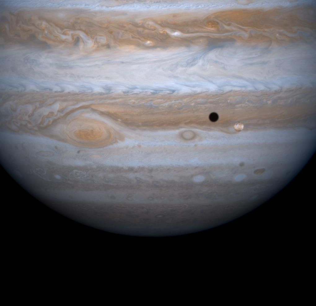 Jupiter's four largest satellites, including Io, the golden ornament in front of Jupiter in this image from NASA's Cassini spacecraft, have fascinated Earthlings ever since Galileo Galilei discovered them in 1610 in one of his first astronomical uses of the telescope.