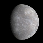 Within the light gray of Mercury's surface are splatters of pale blue, as the left side of the planet is in shadow.