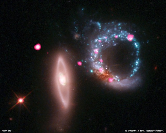 Left: a disk galaxy that appears nearly edge-on to our line of sight with its long axis vertical and just left of image center. It has a bright core with a smooth ring of starlight surrounding it. Right: a ring galaxy. Its pancake-shaped disk of material appears is a clumpy blue ring of intense star formation. A dusty reddish blob at the bottom of the blue ring may be the galaxy’s original nucleus.