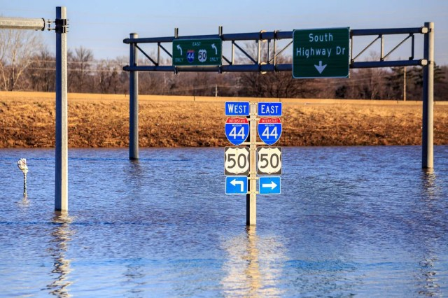 Photo of flood waters submerging highway road signs