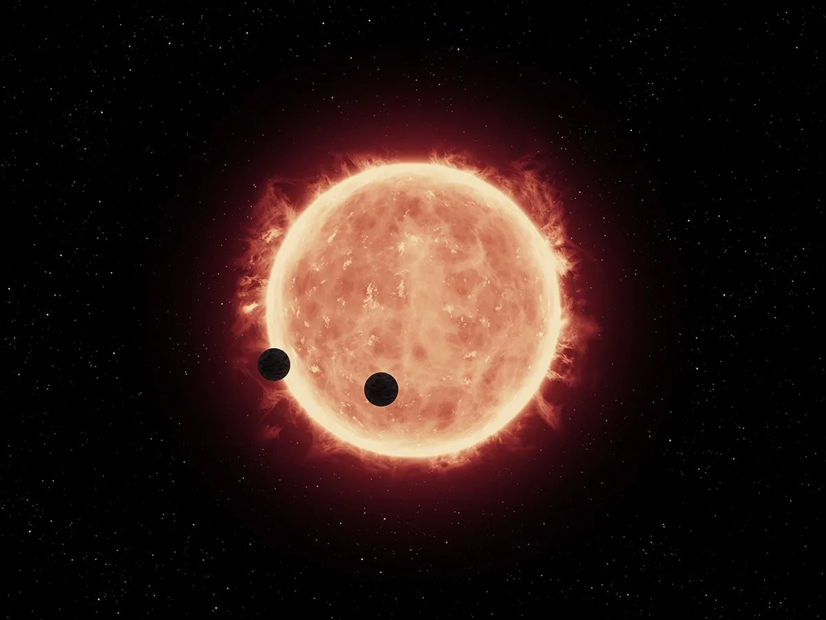 This artist's illustration shows two Earth-sized planets (TRAPPIST-1b and TRAPPIST-1c) passing in front of their parent star.