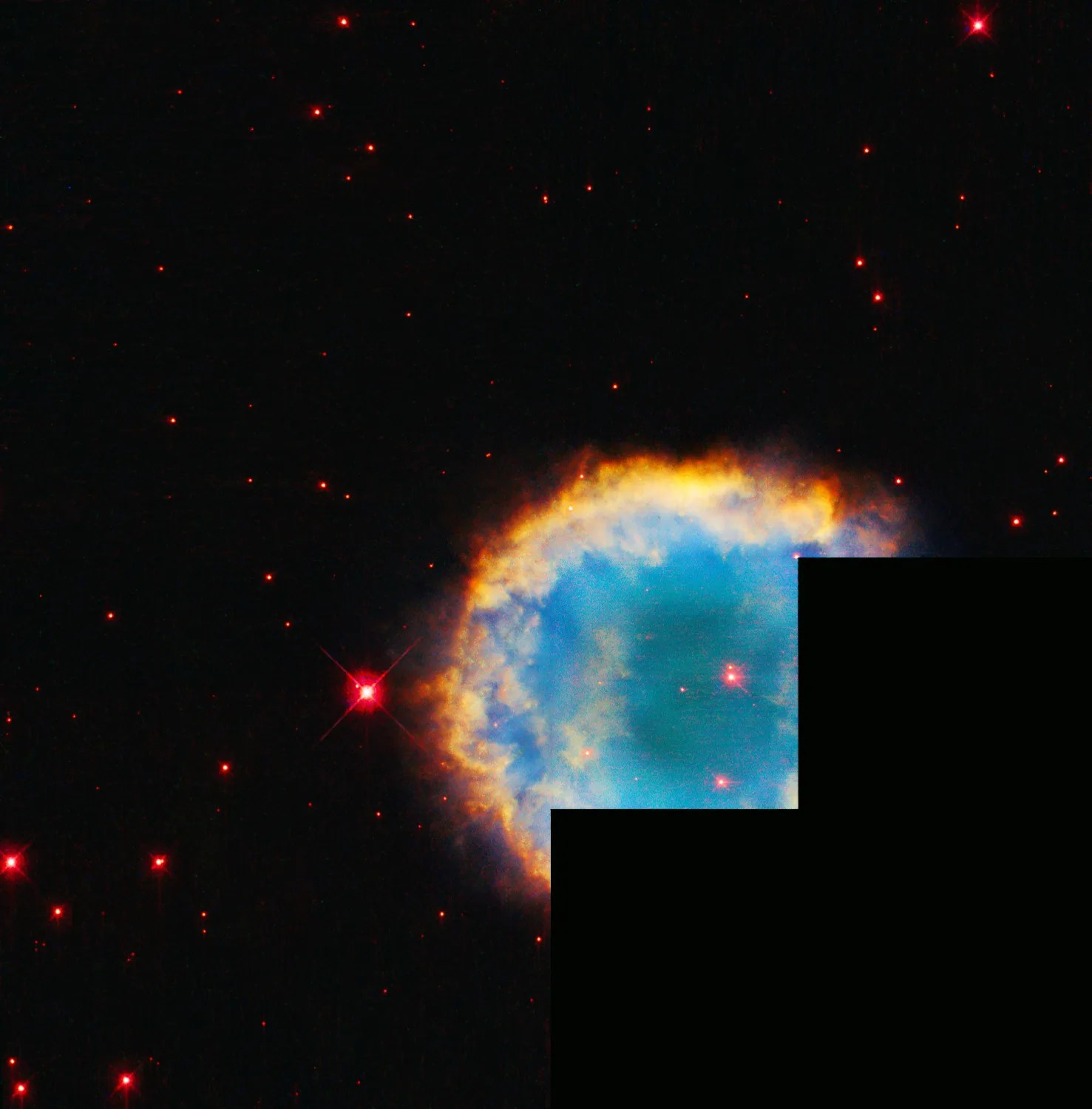 Red-orange and yellow ring the turquoise center of this spherical planetary nebula