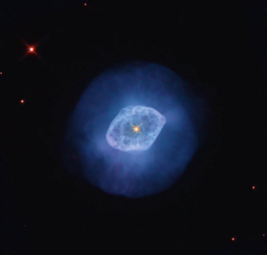 Bright blue nebula with a darker blue halo and a bright orange-yellow star at its center