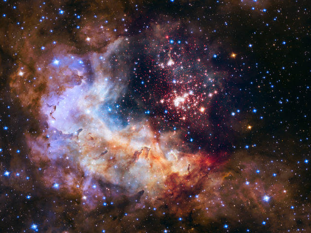 The brilliant tapestry of young stars flaring to life resembles a glittering fireworks display in this Hubble Space Telescope im