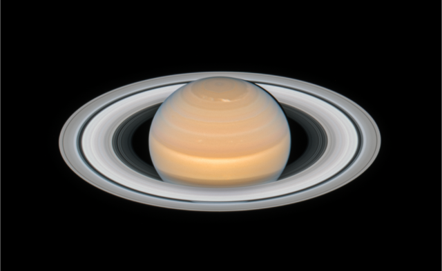 Saturn on a black background. The planet's rings are tilted at a slight angle downward toward Earth.