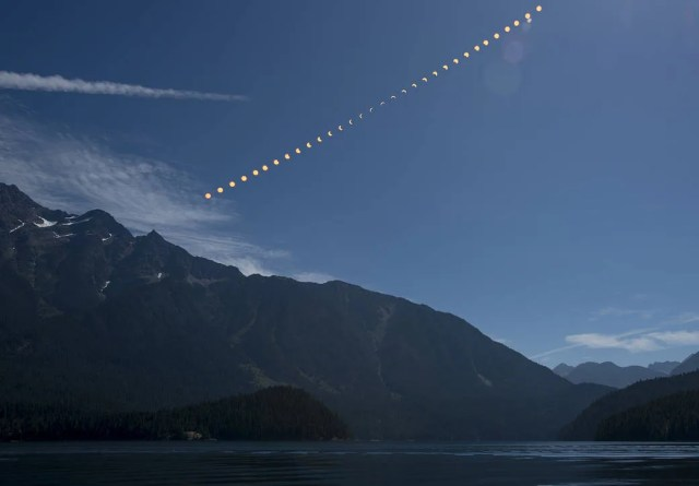 This composite image shows the progression of a partial solar eclipse over Ross Lake, in Northern Cascades National Park, Washington, on Monday, Aug. 21, 2017.