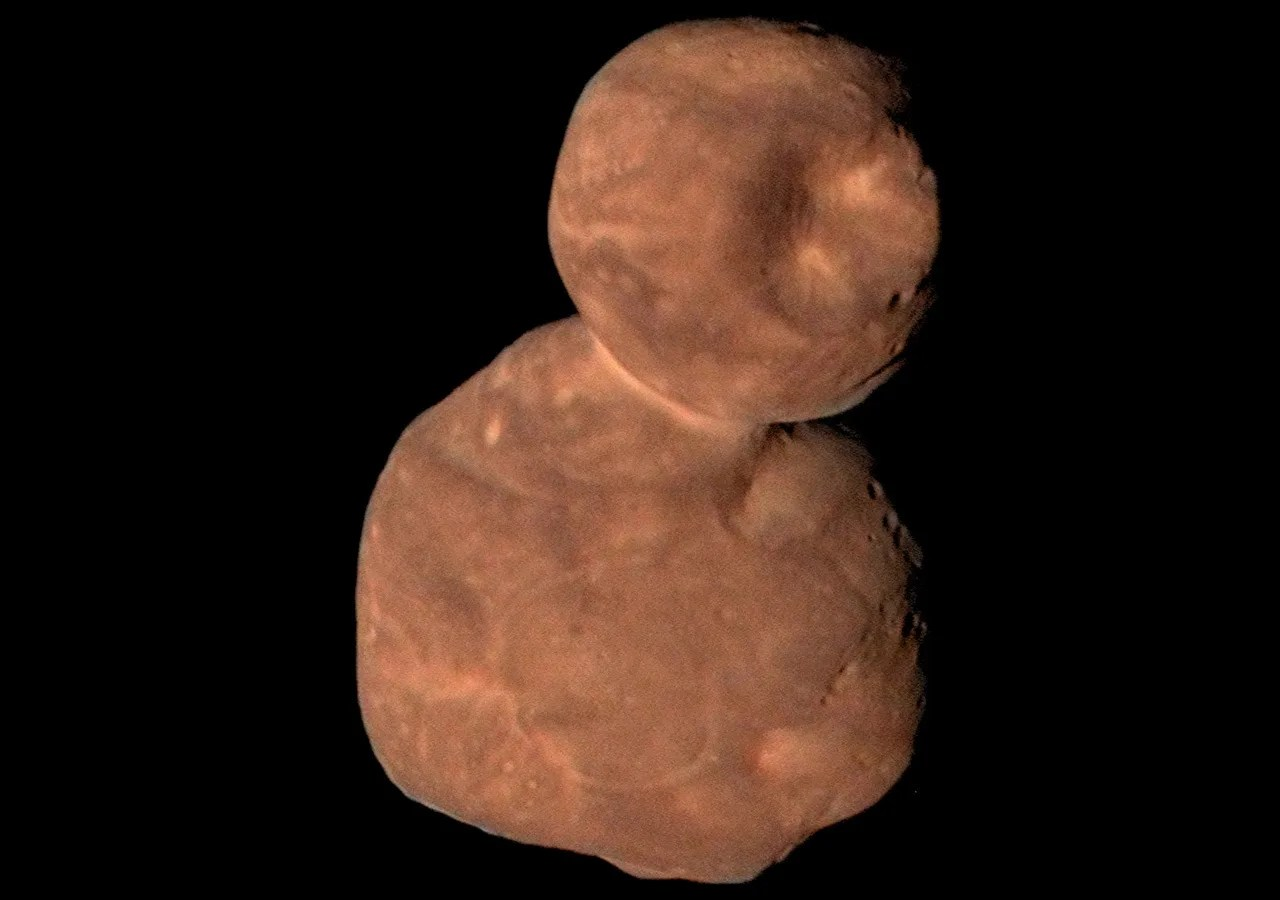 A reddish, snowman-shaped space rock