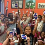 Children showing off their paper rockets and NASA stickers.