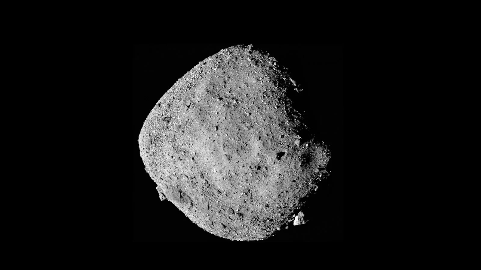 A full disc view of Bennu, whoing its surface littered with giant boulders.