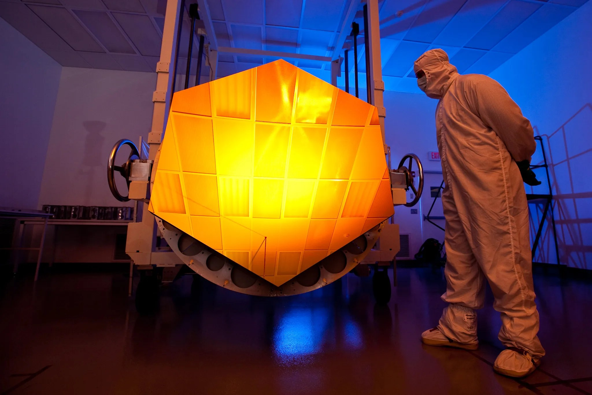 A Engineer looks over one of the James Webb Space Telescope's primary mirror segments.