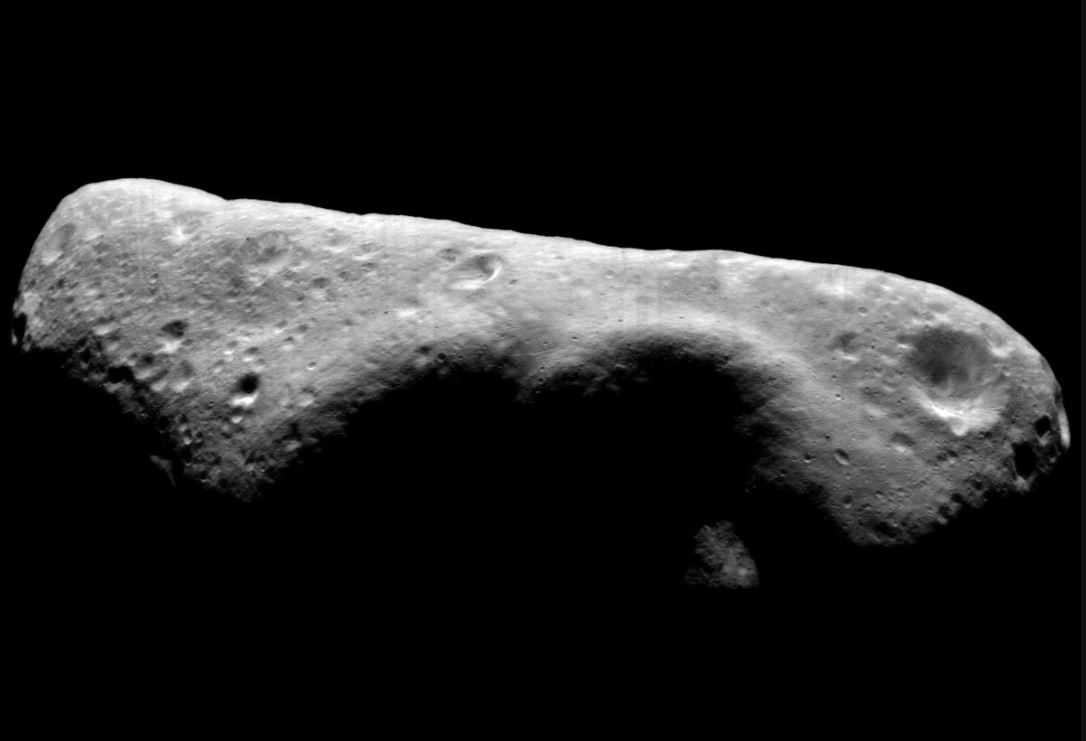 Shades of gray image of rocky asteroid Eros against black sky
