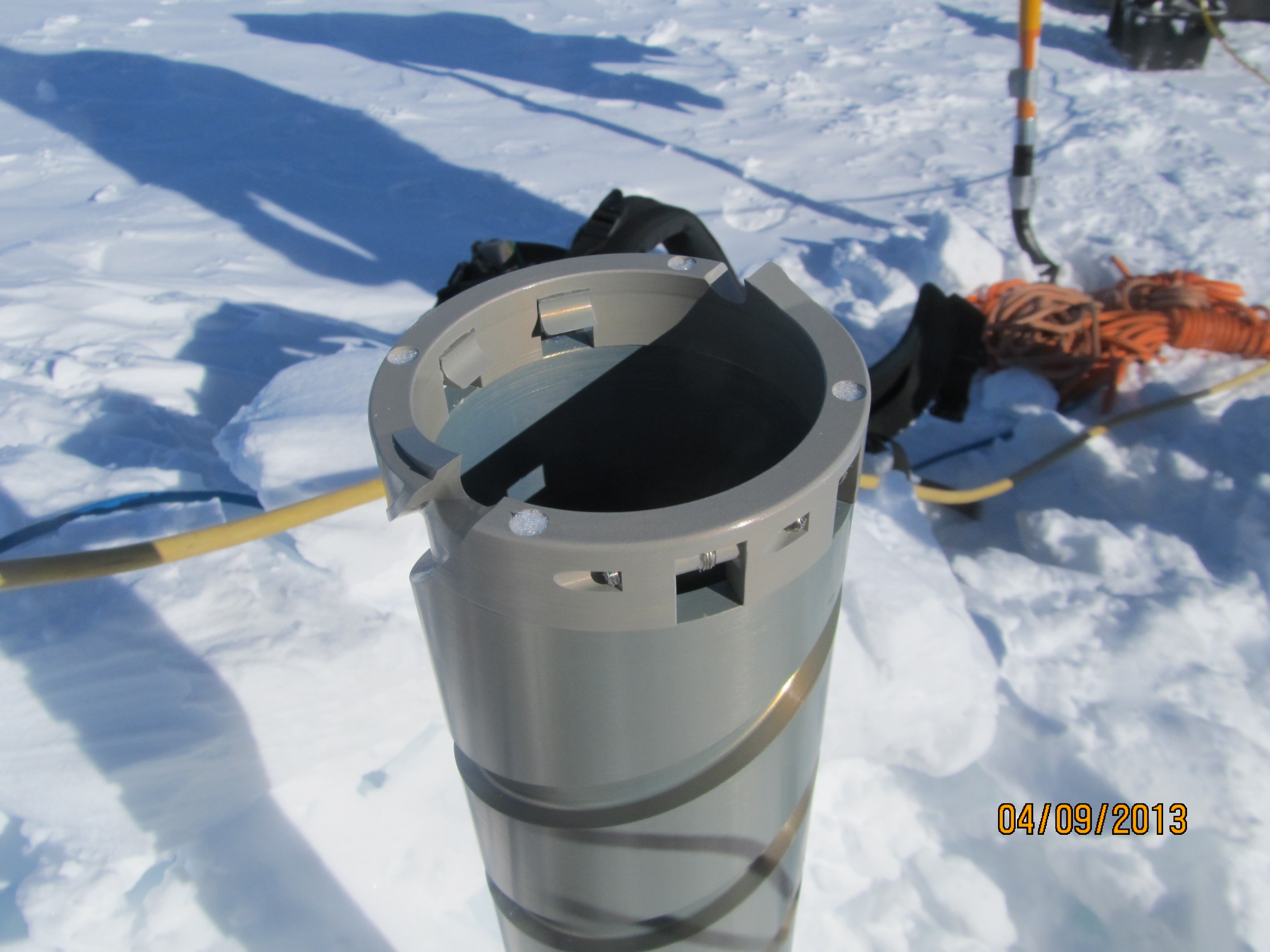 Ice cutters screwed at the bottom of the barrel, which rotates into the ice to extract an ice core.