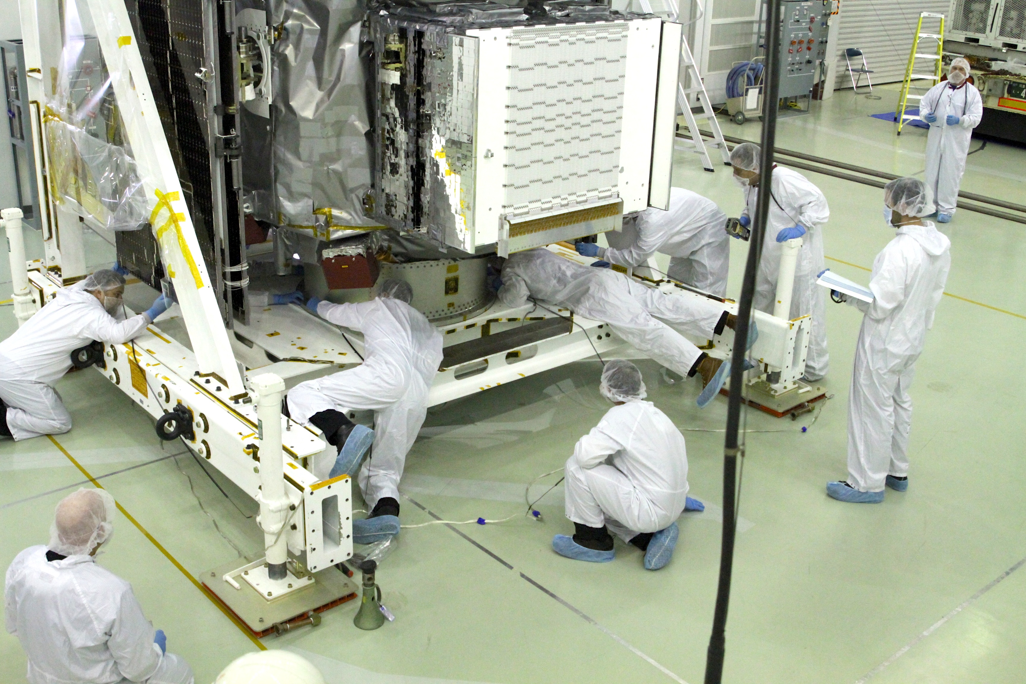 The mechanical team has only a few inches of clearance between the L-frame and the satellite. Credit: NASA / Michael Starobin