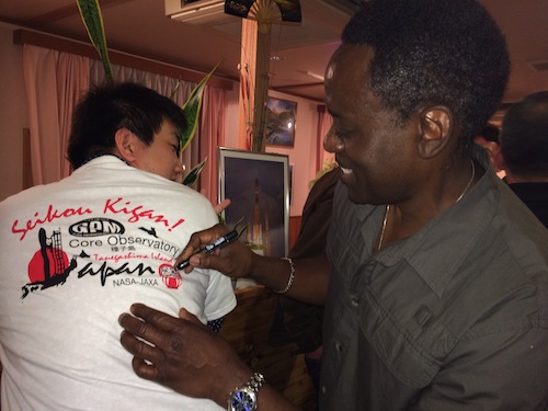 Larry Morgan, quality assurance, fills in the eye of the Daruma doll on the back of a MHI engineer's t-shirt. Credit: Lynette Marbley
