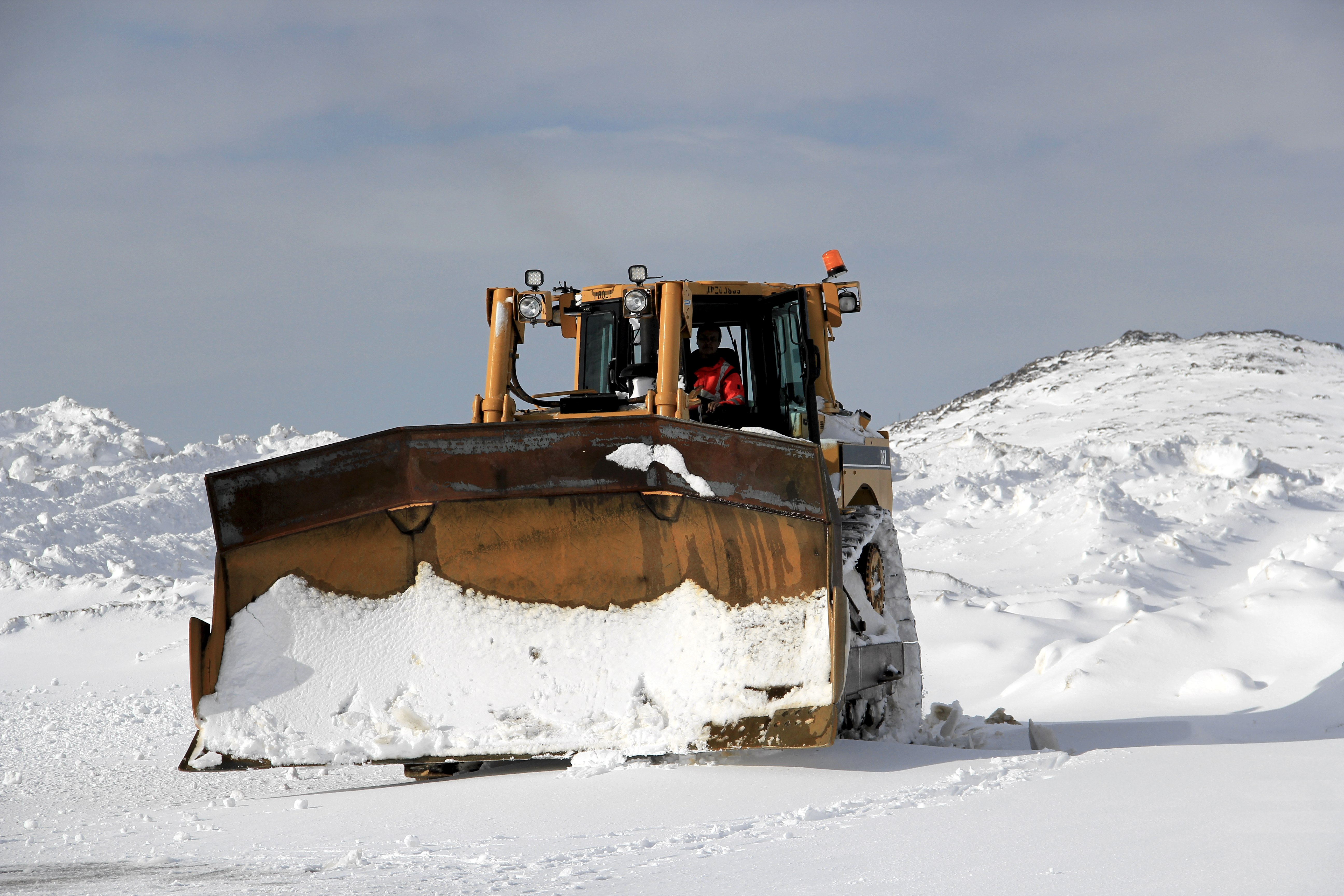 A snow plow removes snow from the second storm of the week at the Kulusuk airport . (credit: Clément Miège.)