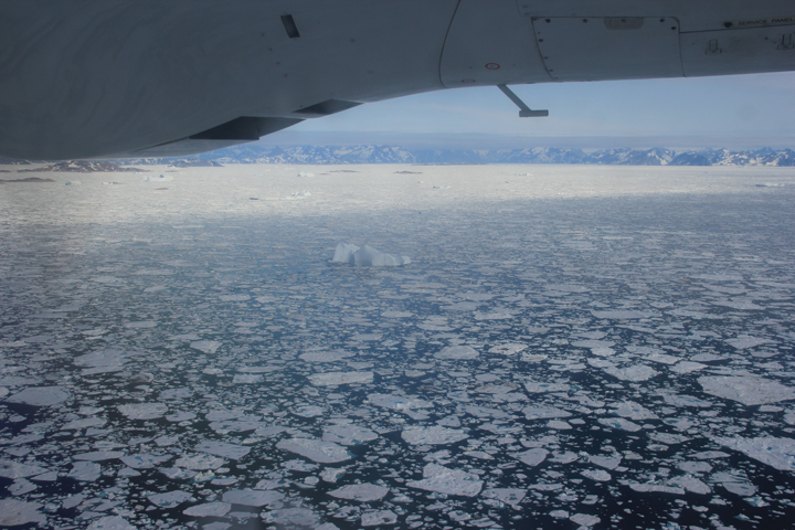 View from flight into Kulusuk with broken up sea ice (flat round ice) and ice bergs that have calved from the nearby glaciers (taller more jagged ice).