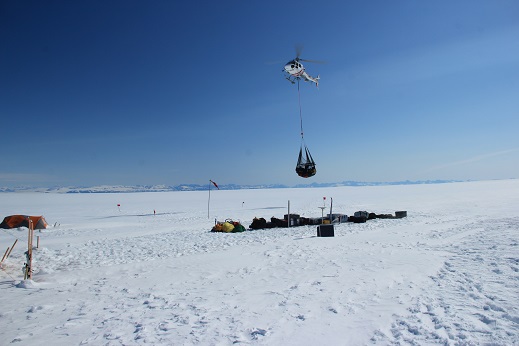The helicopter taking in a sling load full of our gear.