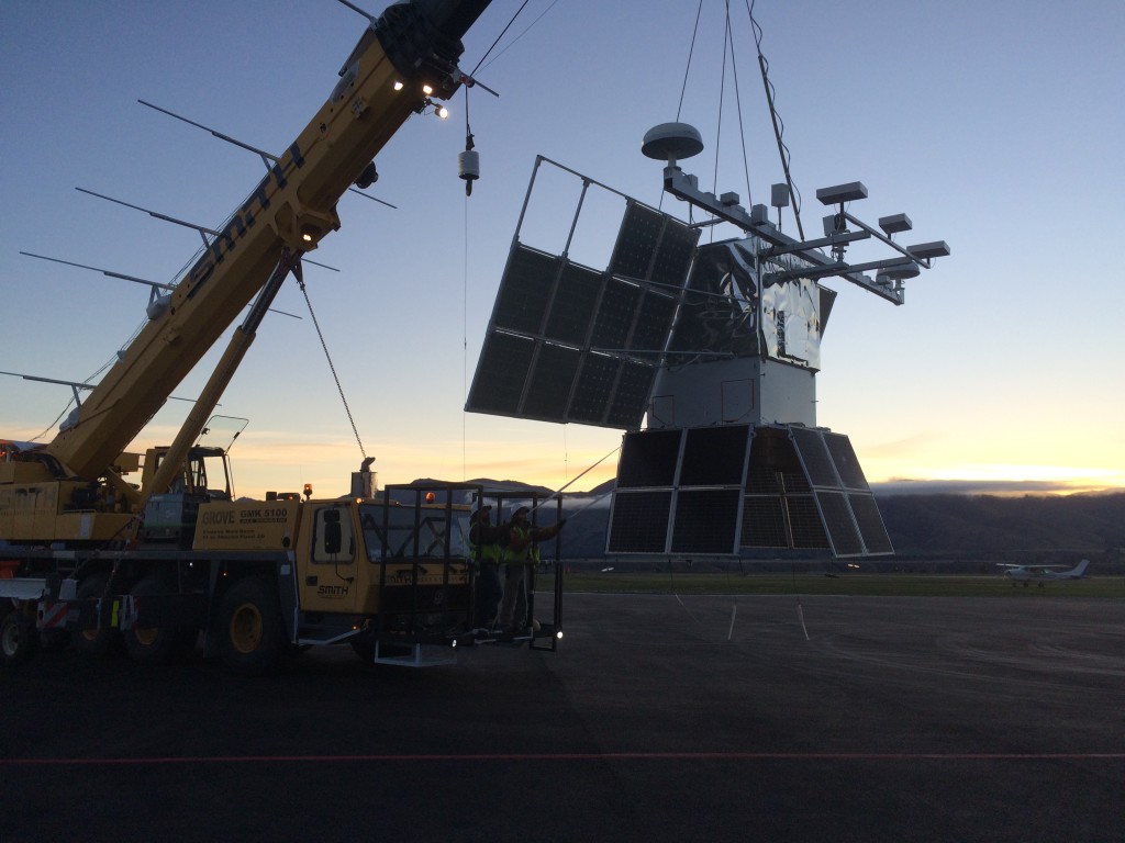 COSI payload hangs from a yellow crane as it returns from flight line