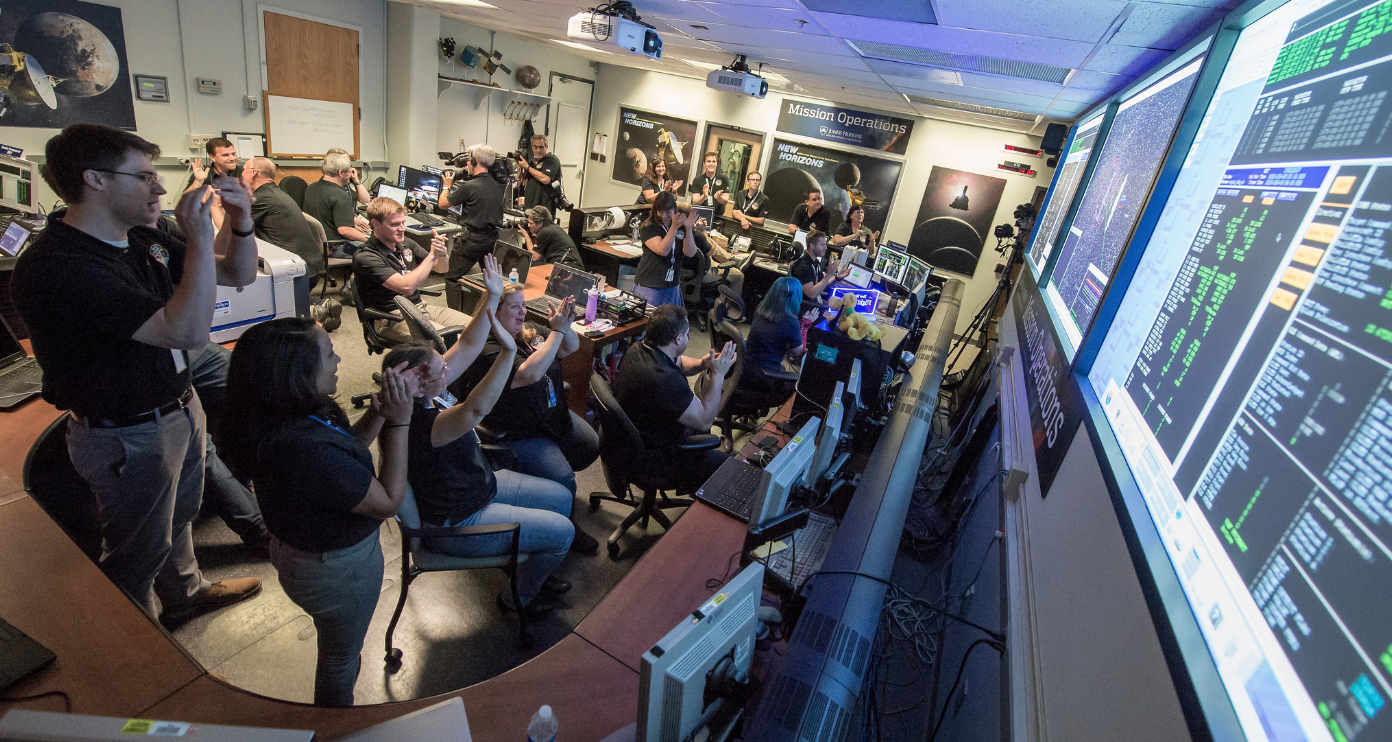 New Horizons Flight Controllers celebrate after receiving confirmation from the spacecraft that it had successfully completed the flyby of Pluto, Mission Operations Center (MOC) of the Johns Hopkins University Applied Physics Laboratory (APL), Laurel, Maryland. Credits: (NASA/Bill Ingalls)