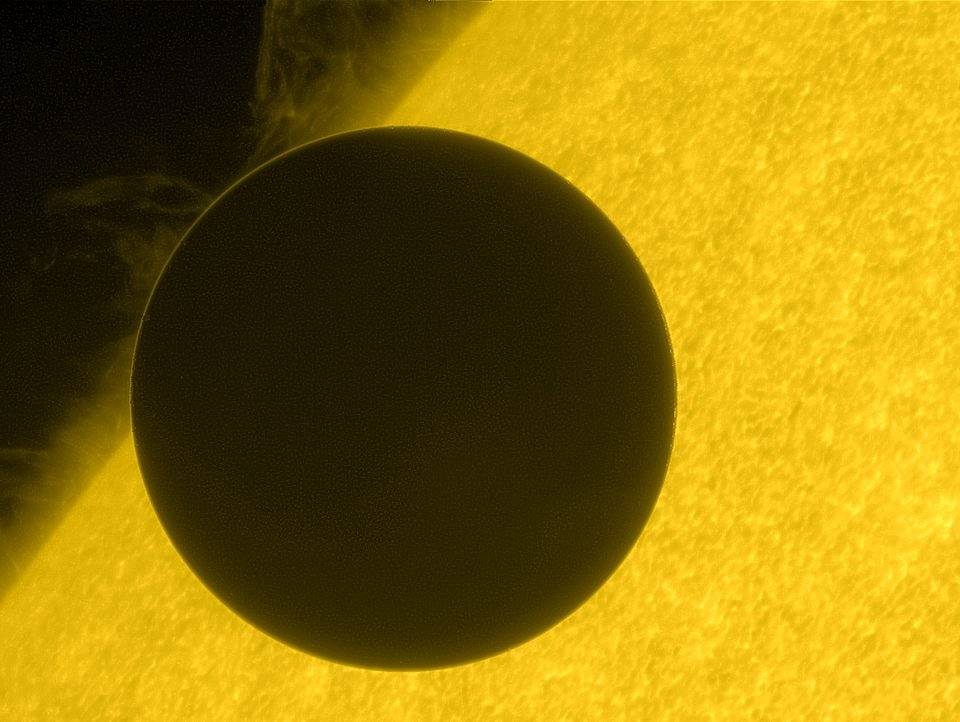 transit of Venus - a black circle passes in front of a yellow sun.
