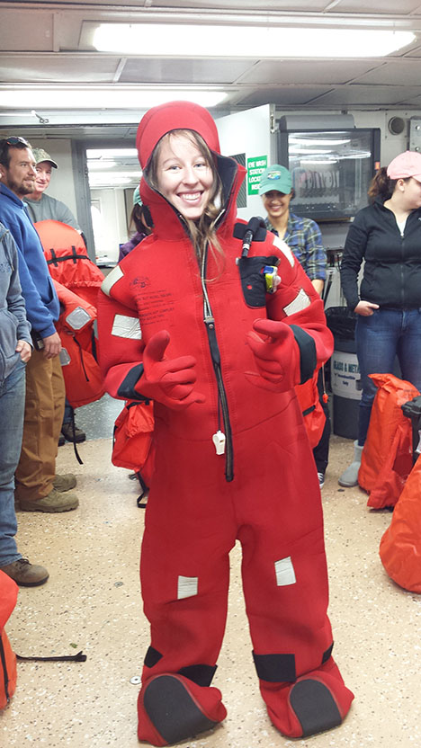 Kelsey McBeain, a master’s student from the lab of Kim Halsey, dons the survival suit during the safety drills. Photo: Kristina Mojica