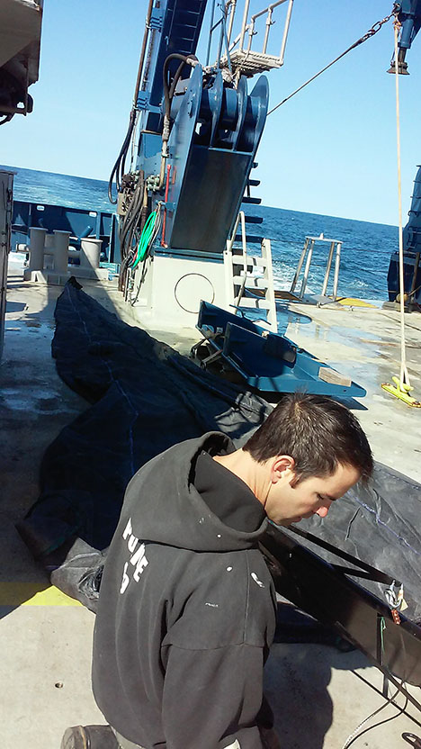 Crew member Ronnie Whims laying out the mesopelagic fish net on the aft deck of the RV Atlantis. Photo: Kelsey McBeain