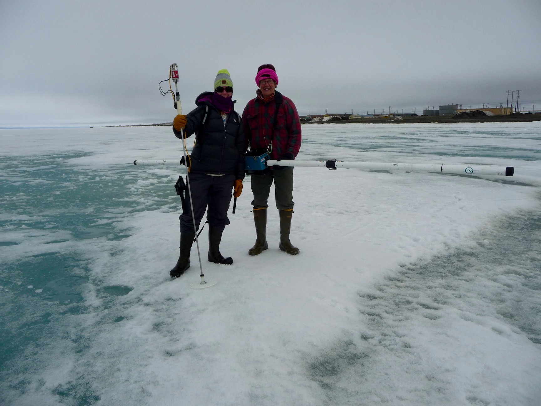 Two members of the Red Team holding the electromagnetic induction instrument to measure sea ice thickness.