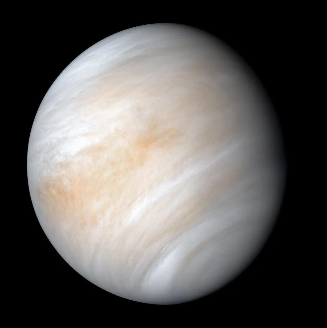 Storm clouds in white and pale red encircle Venus.