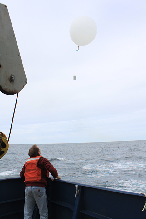 The balloon and radiosonde are walked to the back of the ship's fantail and released. As the package rises it sends back the data by a radio link to make a vertical profile of temperature, humidity and winds. Photo: Jim Johnson