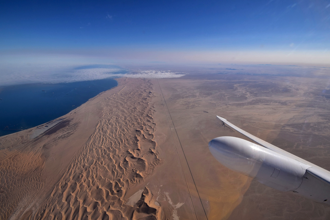 Swakopmund is under the clouds in the photo, at the end of the straight dirt road that runs 20 miles along the dunes between town and Walvis Bay Airport. Credit: Stu Broce