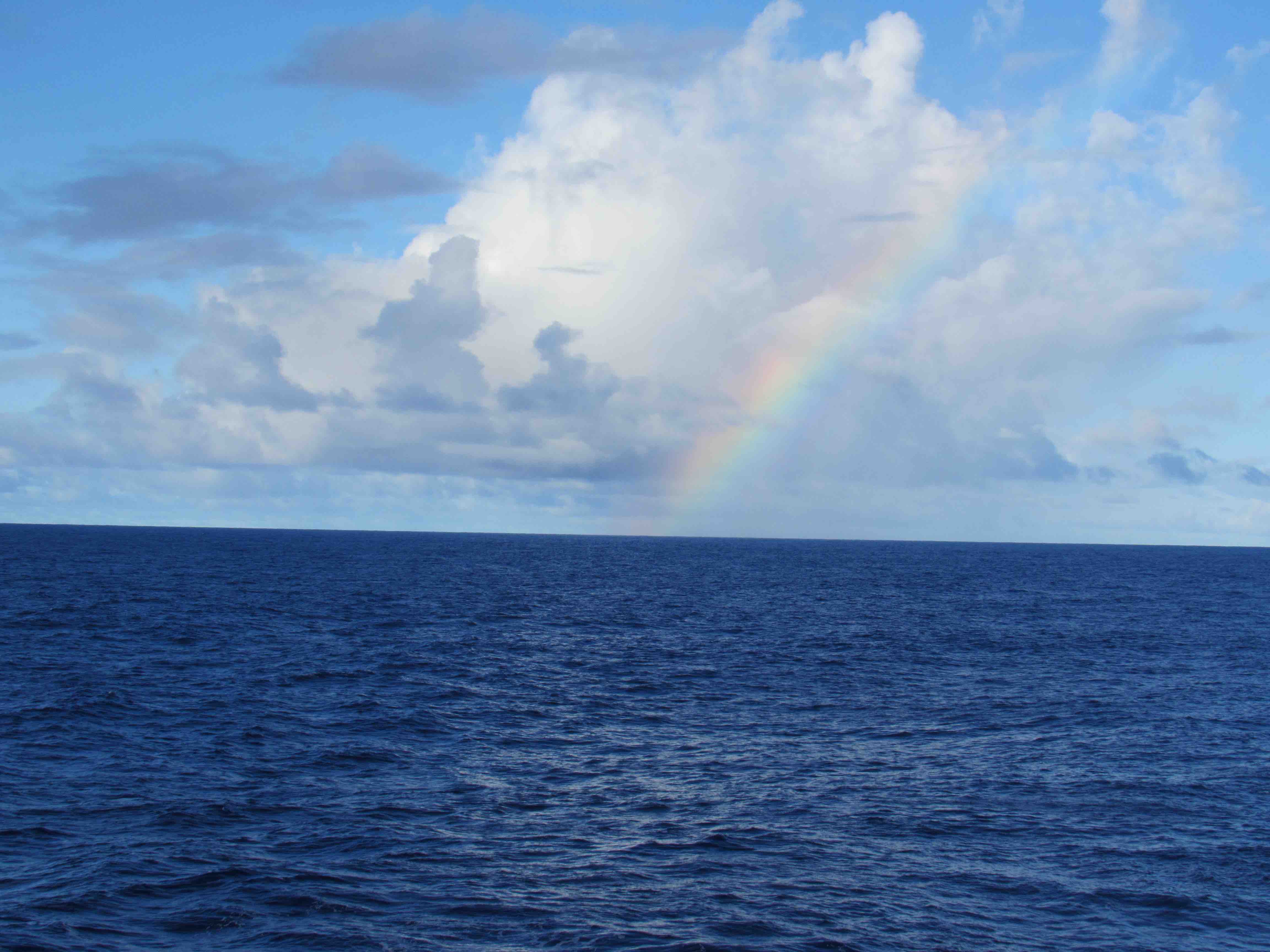 Blue sea and sky, with a nice rainbow.