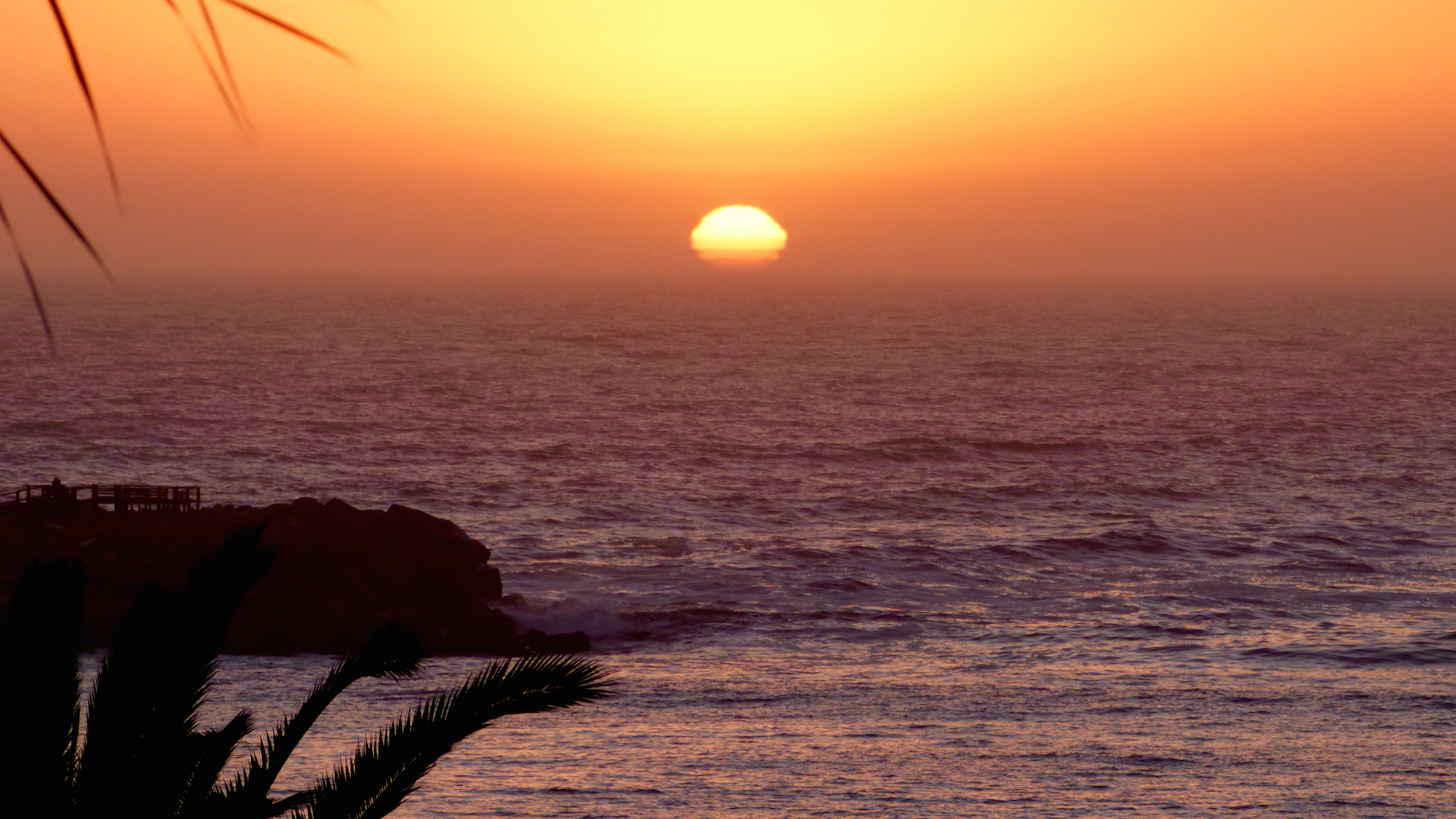 A dusty, smokey, sunset over the Atlantic Ocean from the Namibian coast. Credit: Mike Tosca