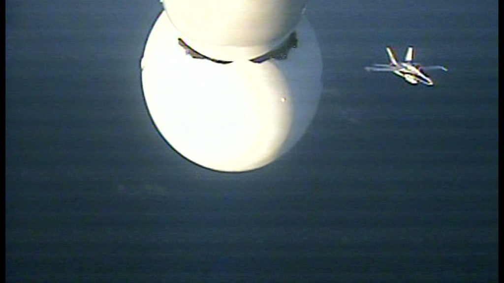 The chase plane is visible below the Pegasus XL rocket in this image from a camera mounted to the underside of the L-1011.