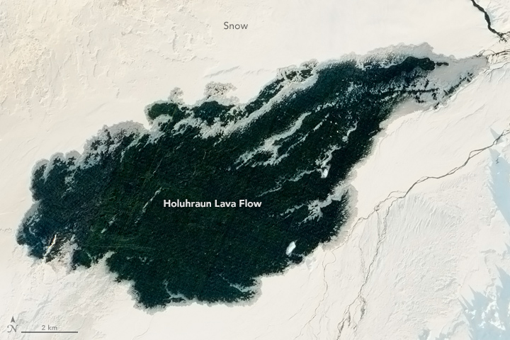 Holuhraun’s 2015 flow appears dark against the Icelandic snowscape. Image: NASA Earth Observatory/Jesse Allen, using EO-1 ALI data provided courtesy of the NASA EO-1 team.