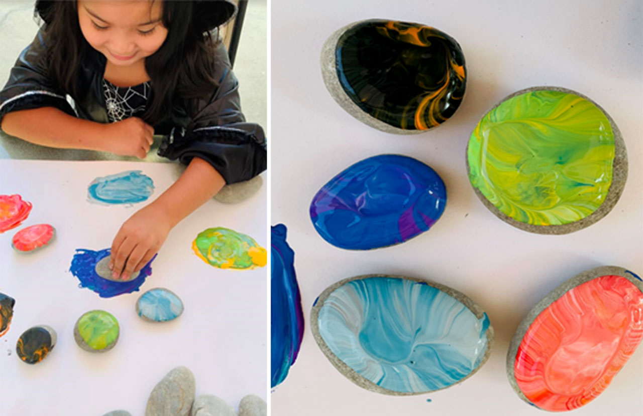 Child doing a colorful art project with paint and rocks