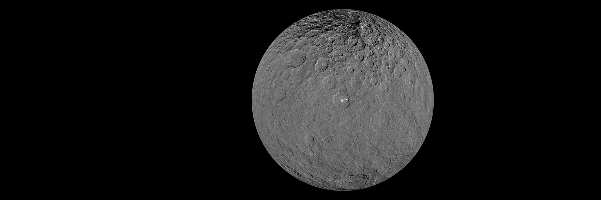 Dwarf planet Ceres appears gray with white splotches in this image from the Dawn spacecraft.