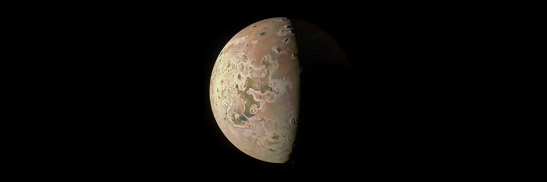 Partially lit moon Io.