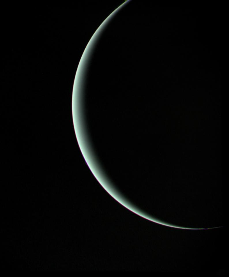 A dimly lit crescent of planet Uranus.