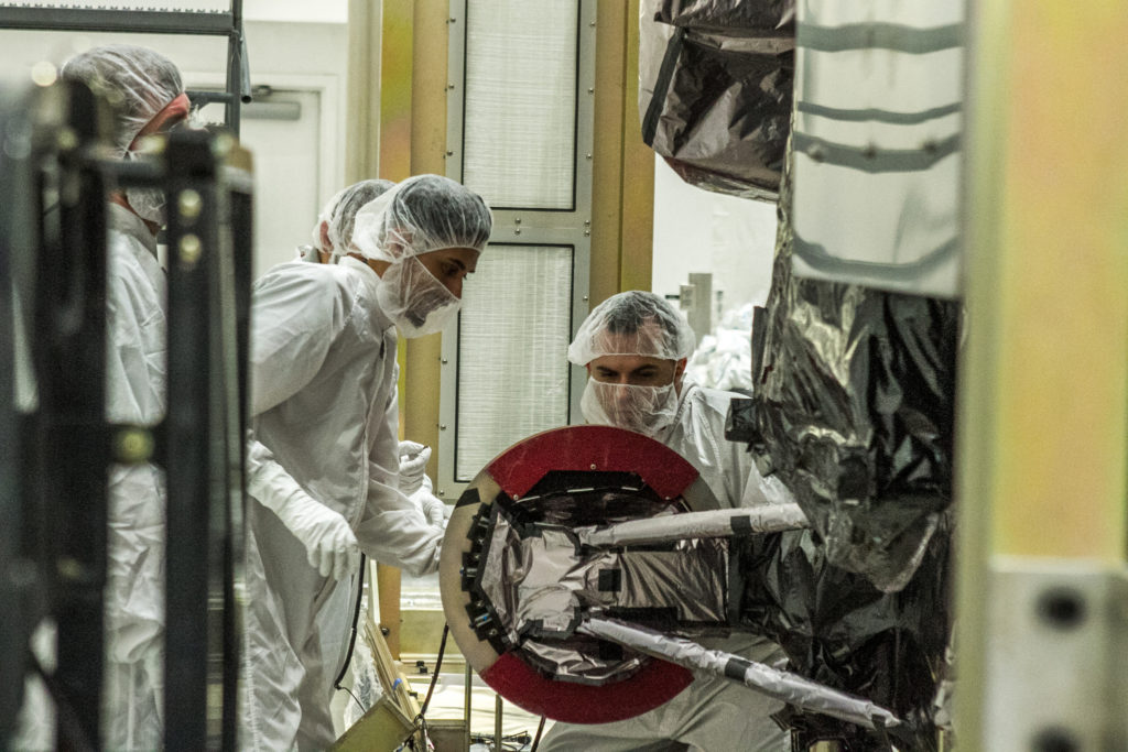 At Astrotech Space Operations in Titusville, Florida, technicians and engineers inspect NOAA's GOES-S sateliite after removal from its shipping container.