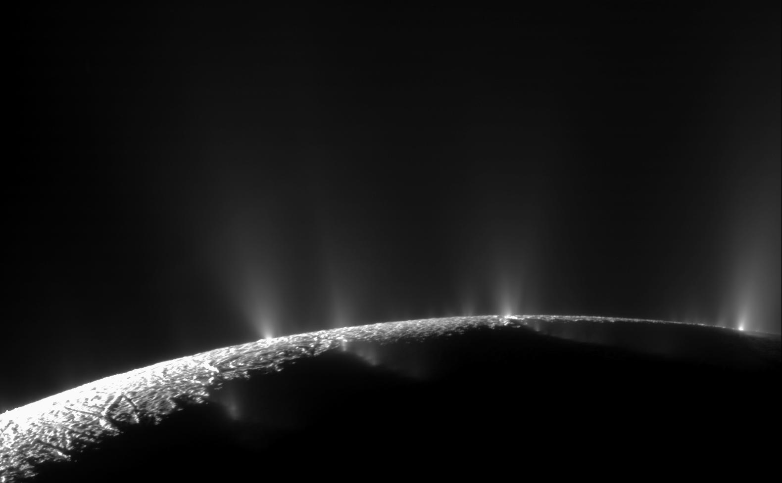 The curve of Enceladus with white spray above