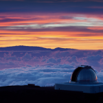 Orange and purple sunset sky with clouds below and domed telescope in the lower right corner