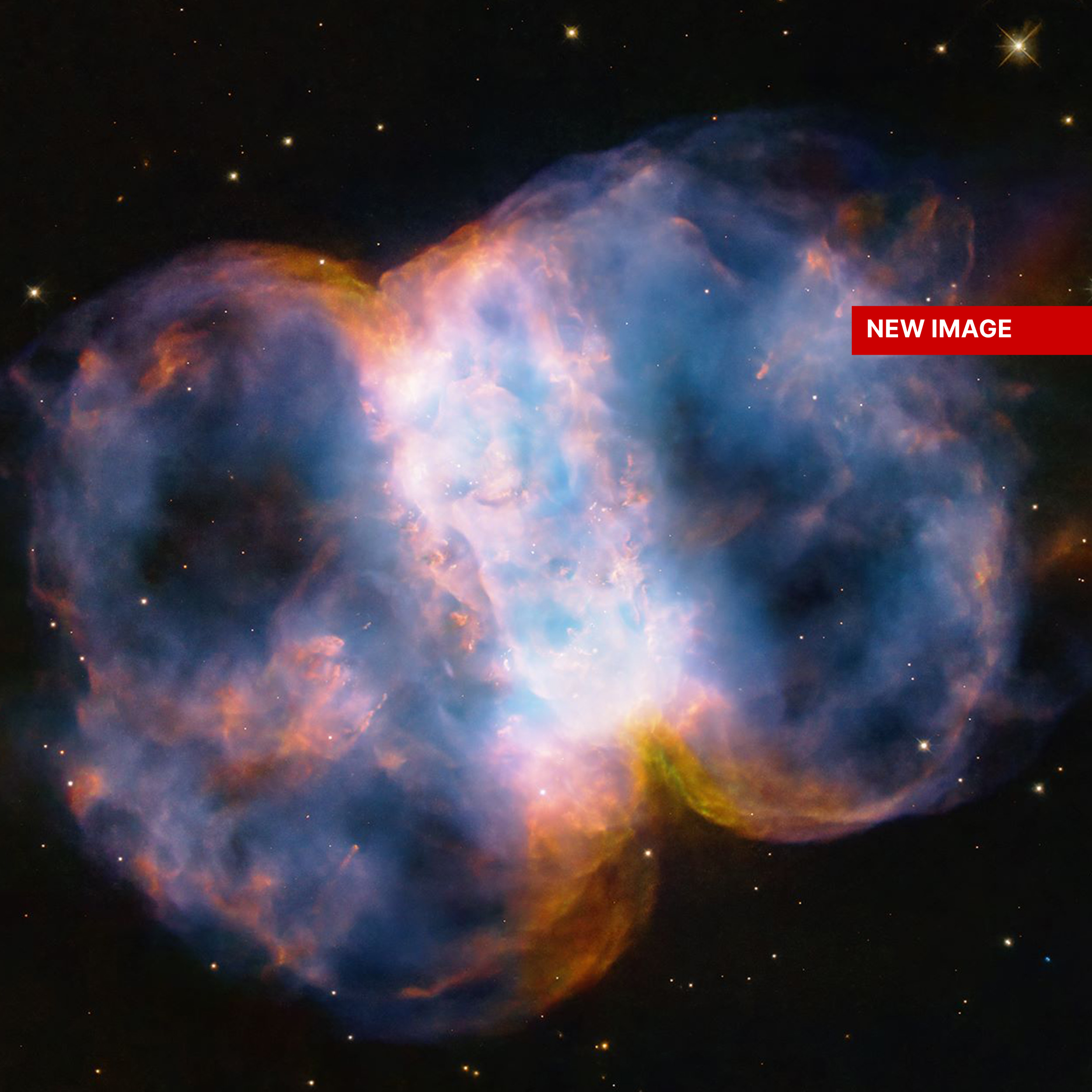 Taking up most of the image, is a multi-colored nebula appearing as two translucent orbs attached by a white band.